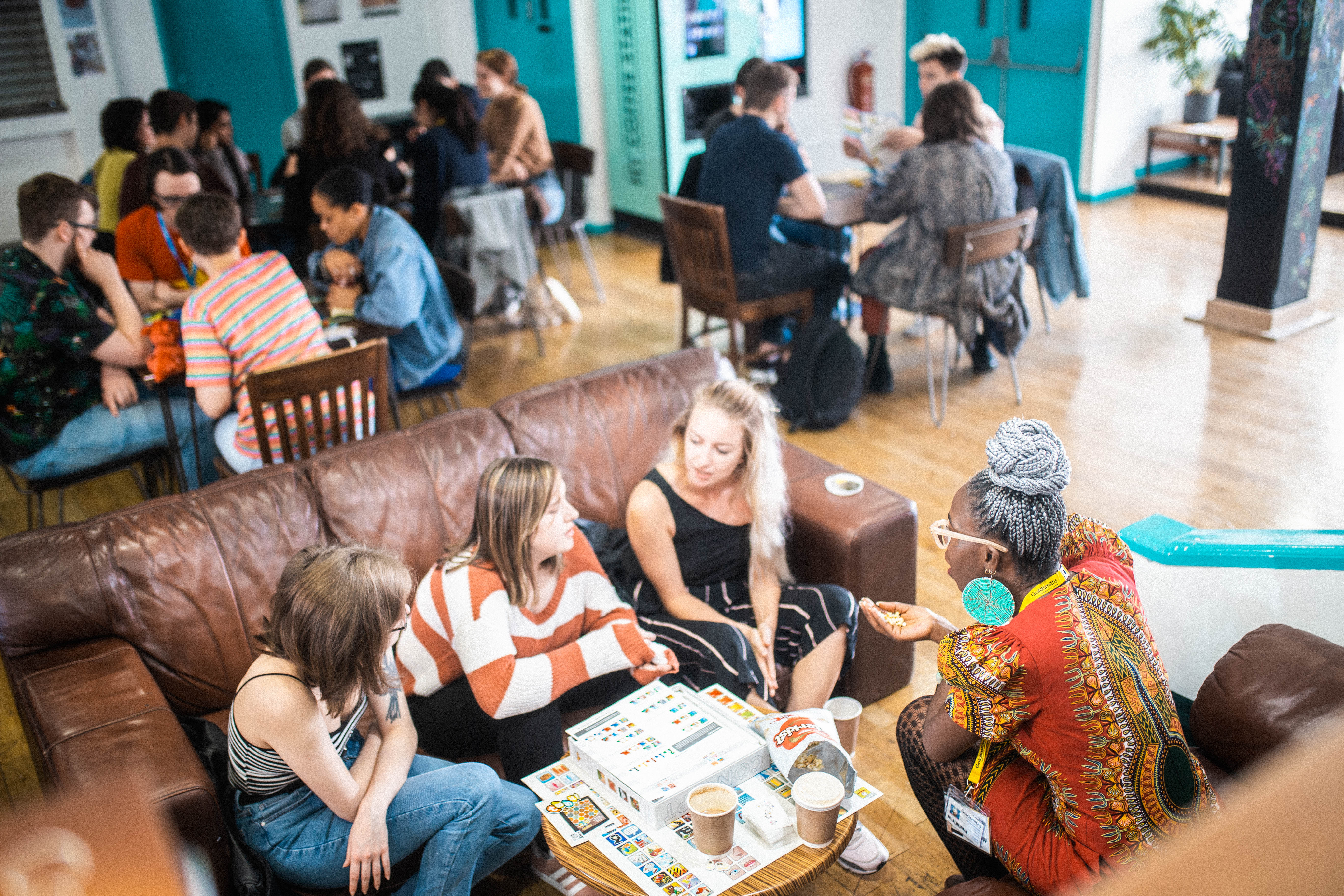 Photograph of people seated on couches in a busy coffee shop.
