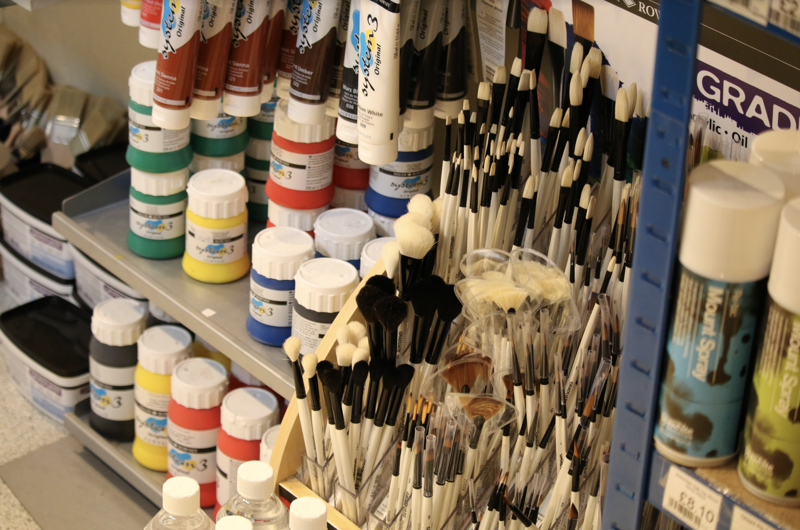 Photograph of painting supplies such as paint, brushes and spraypaint.