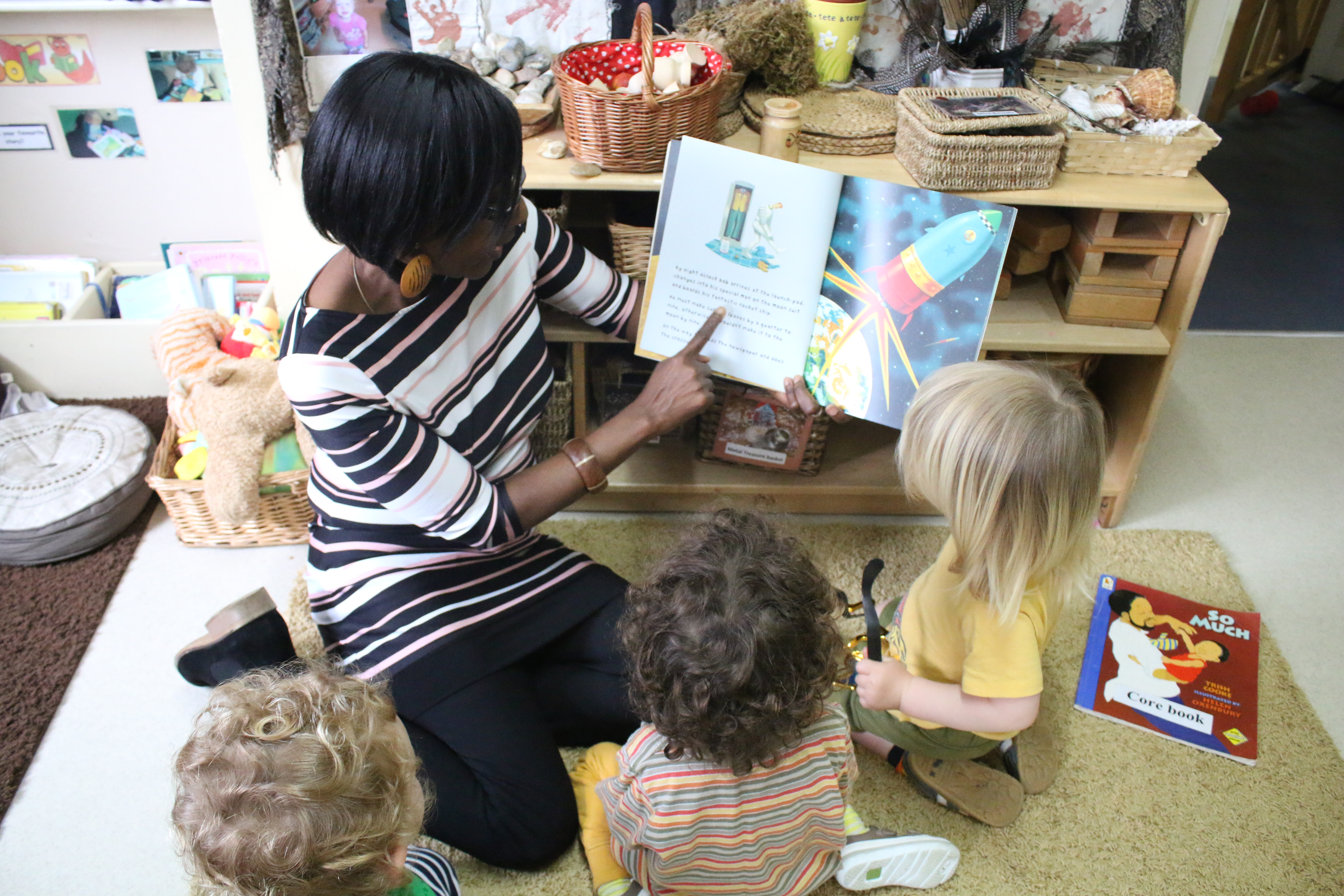 Photograph of staff reading to children in nursery