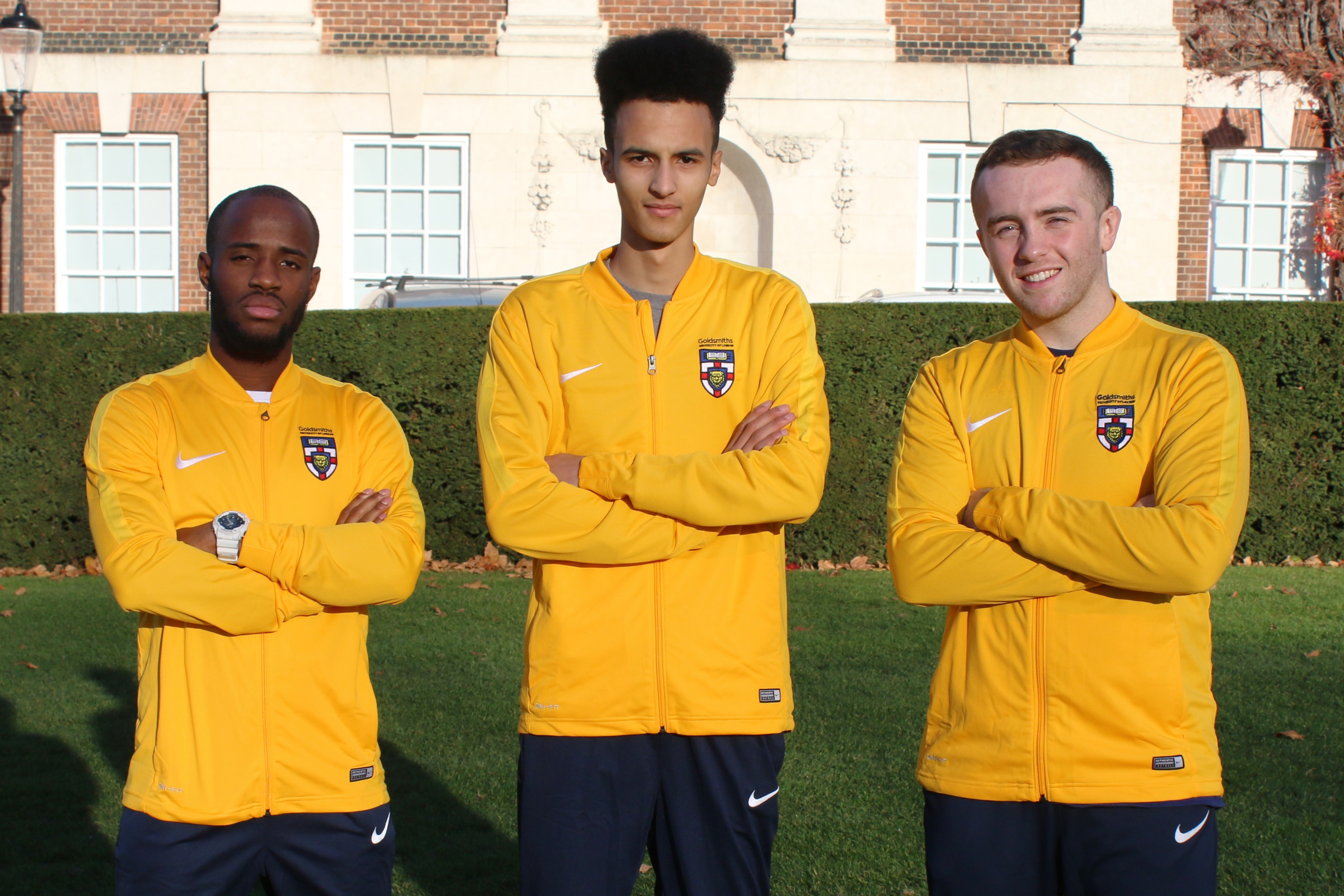Photo of three athletes in a row, posing with their arms crossed.